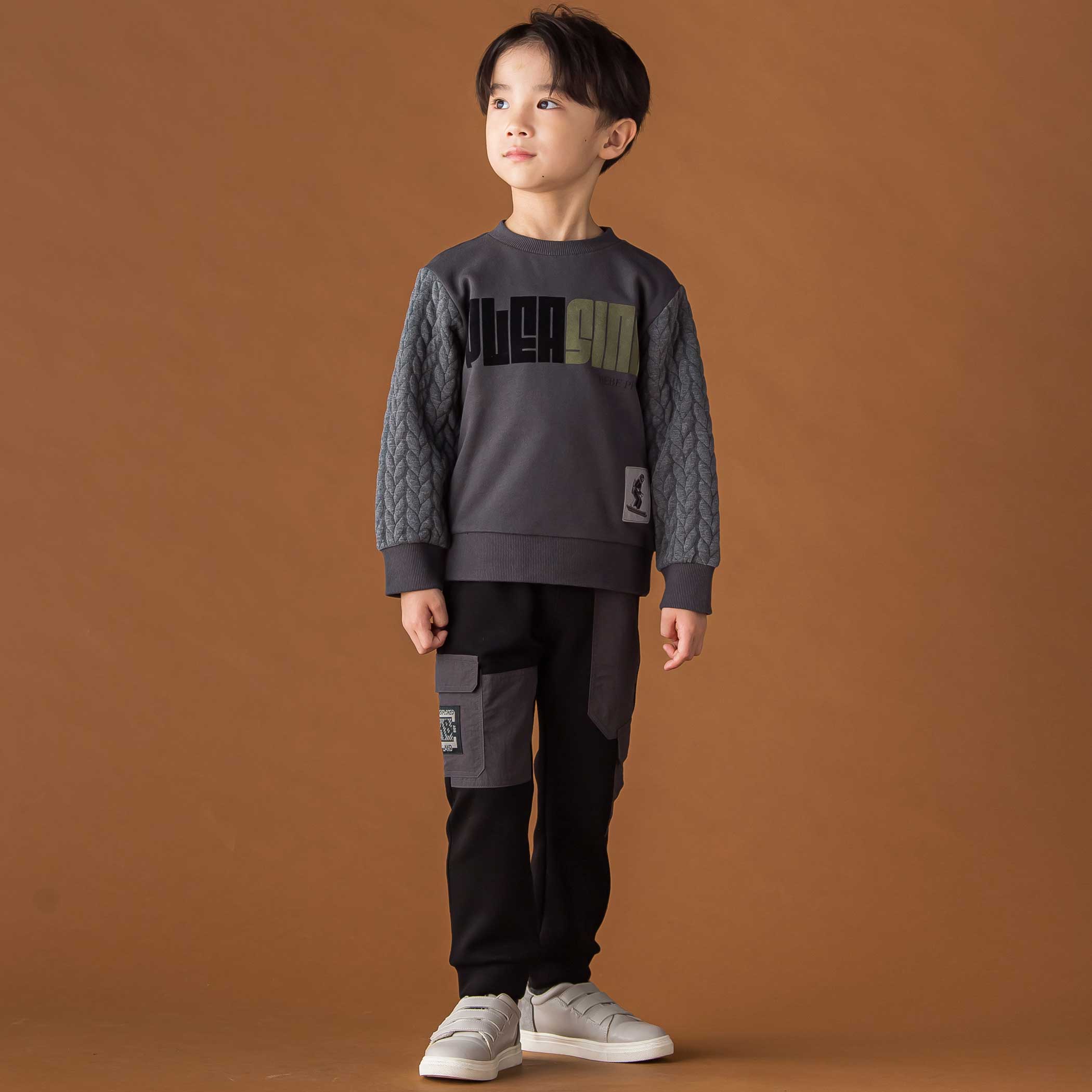 袖キルトトレーナーと裏起毛切り替えパンツの個性派BOY’Sスタイル。ネイビーのトレーナーとアシンメトリーなブラックロングパンツの全身コーディネート