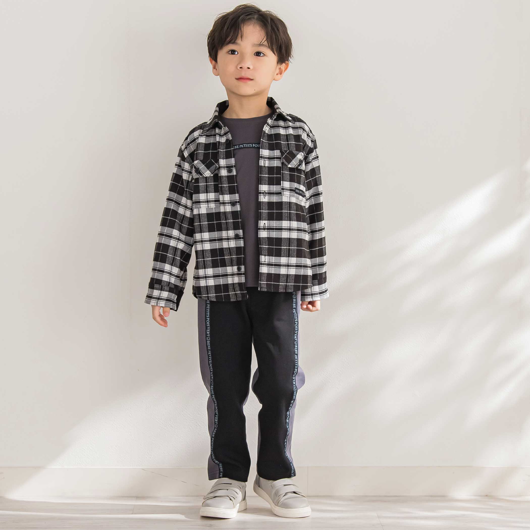 BeBe Petits Pois Vert チェックシャツとロゴ切り替えパンツを合わせたクールスタイルを着た男の子の全身コーディネート画像