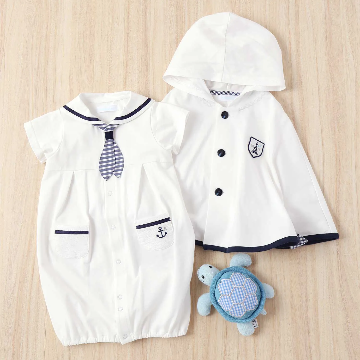 上品なホワイトのマントとロンパースにカメさんガラガラを添えた出産祝いセット