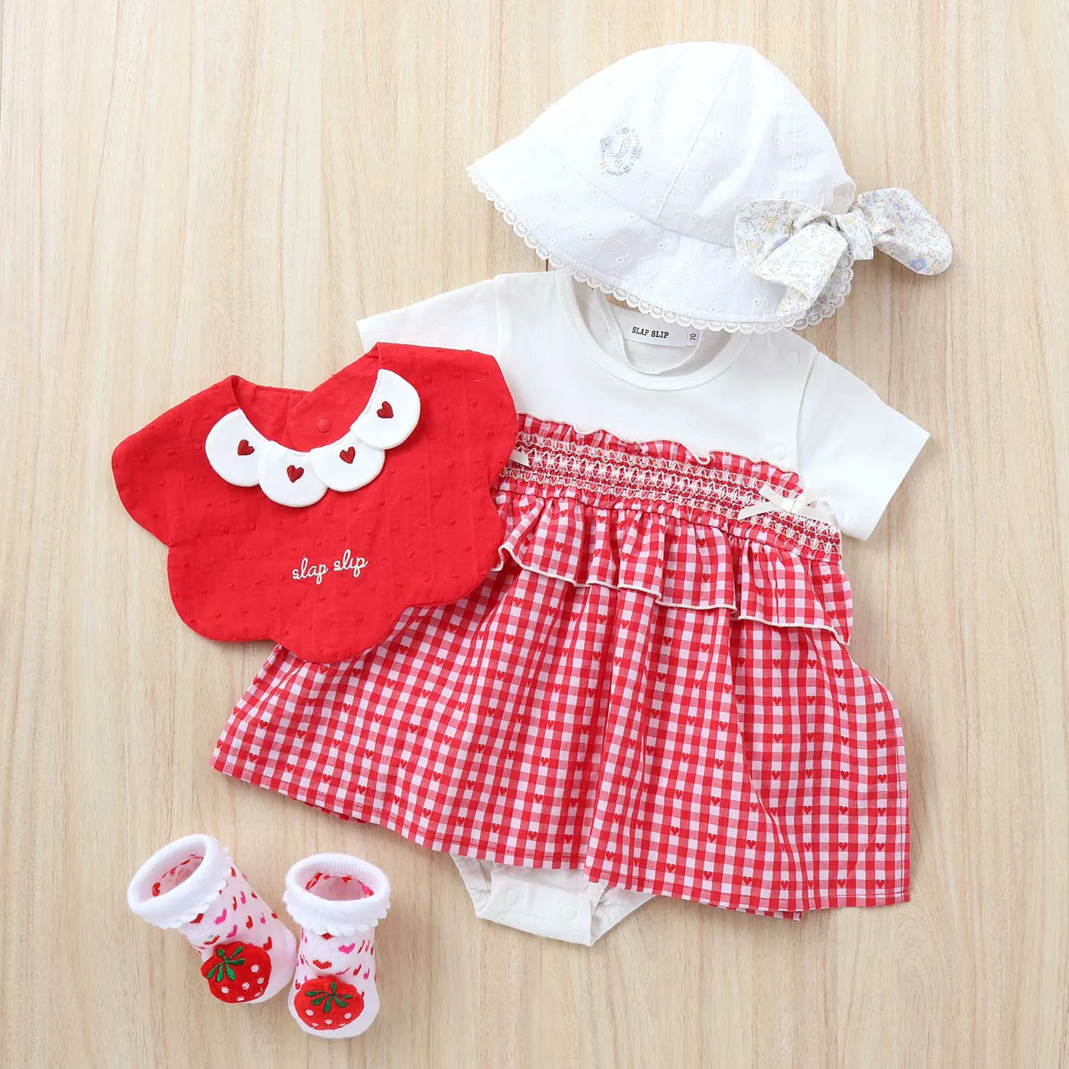 フリルスカート付きロンパースと女の子らしいガーリーなデザインのスタイ・帽子・靴下を合わせて夏映えなコーデギフト