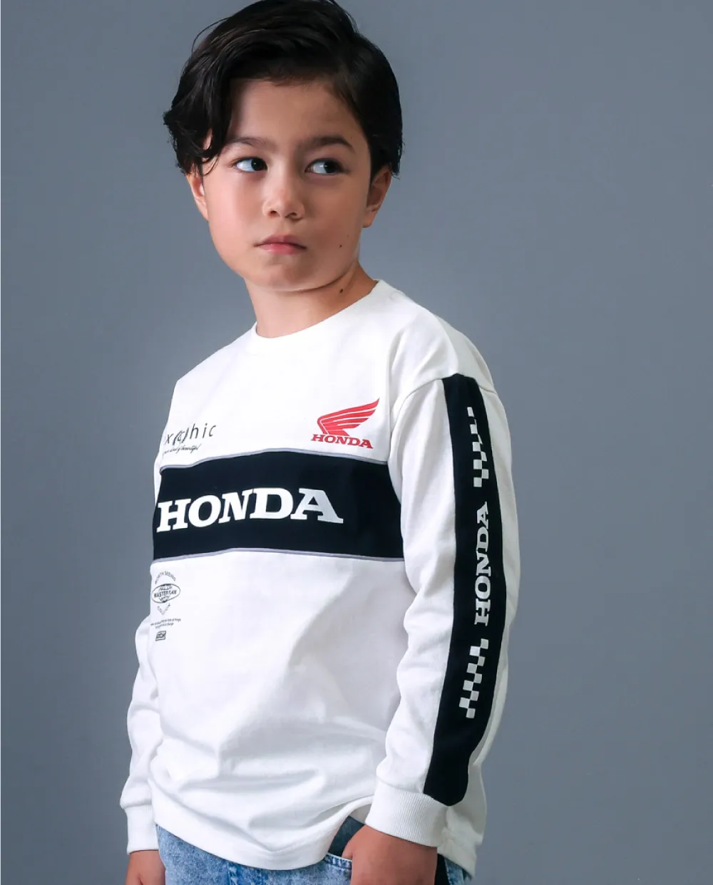 nexchic HONDAコラボ 切り替えトレーナーを着用した子供のコーディネート。ロゴパイピングが特徴