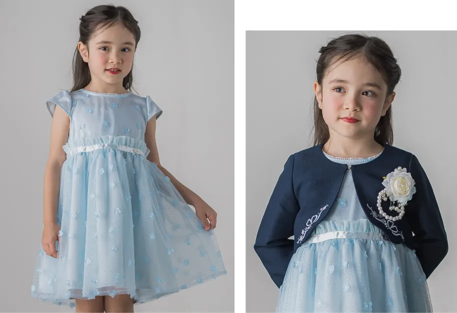 ブルー系のラメチュールワンピースにホワイトコサージュを添えたさわやかなセレモニーコーデのアップ